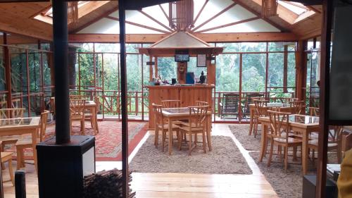 a restaurant with wooden tables and chairs in a pavilion at King Fern Cottage in Nuwara Eliya