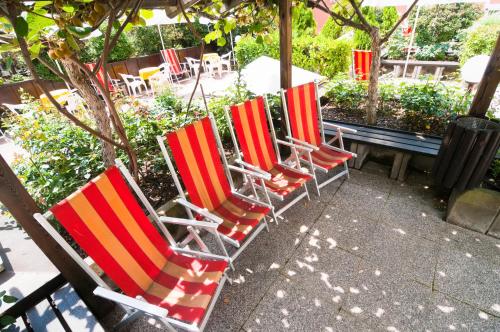 a row of lawn chairs sitting on a patio at Kolpinghaus Bolzano in Bolzano