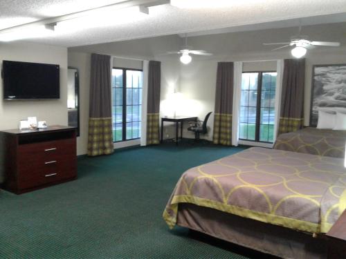a hotel room with a bed and a flat screen tv at Super 8 by Wyndham Austell/Six Flags in Austell
