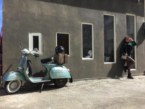 a woman standing next to a scooter parked next to a building at Kenting Sun Light Inn in Eluan