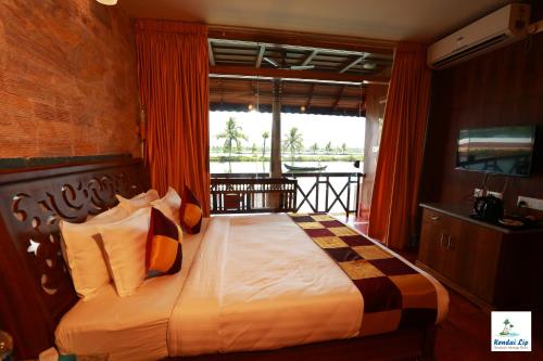 a bedroom with a bed with a view of the ocean at Kondai Lip Backwater Heritage Resort in Cochin