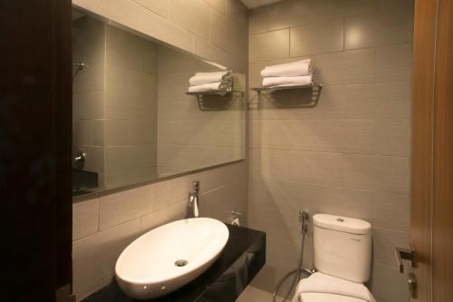 a bathroom with a sink and a toilet and a mirror at Moscato Hotel in Lembang