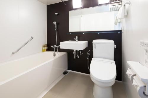 a bathroom with a white toilet and a sink at HOTEL MYSTAYS Shinsaibashi in Osaka