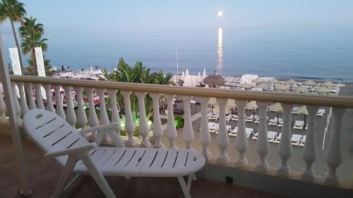 a white bench on a balcony with a view of the ocean at Apartamentos Don Pepe in Torremolinos