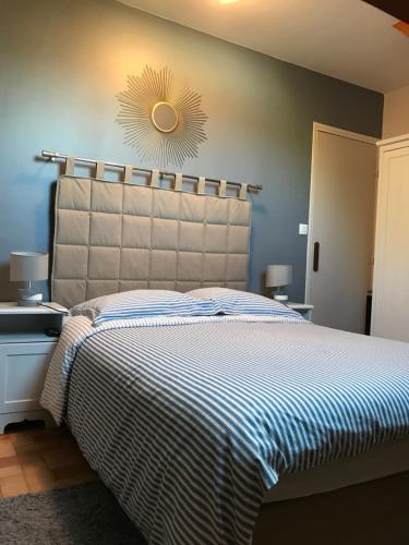 a bedroom with a large bed with a large headboard at La Grille Dorée in Amboise