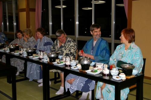 a group of people sitting at a table with food at Bosenkan in Gero