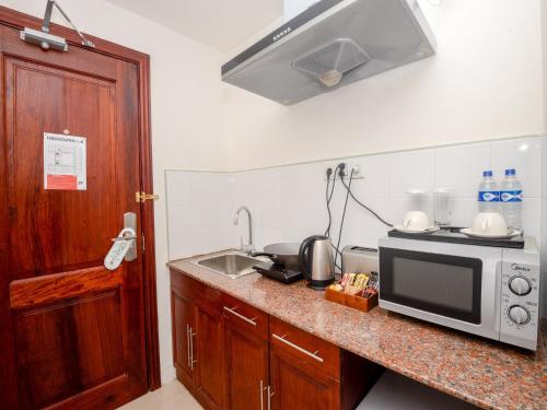 a kitchen with a sink and a microwave on a counter at Raphael's Hotel in Pemba