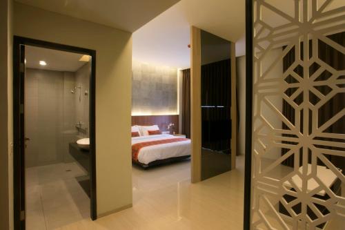 a bedroom with a bed and a sliding glass door at Moscato Hotel in Lembang