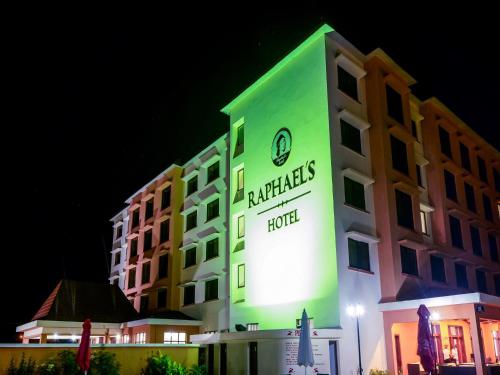 a hotel with a green sign on the side of it at Raphael's Hotel in Pemba
