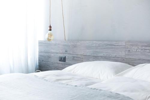 a bedroom with a white bed with a wooden headboard at Seven Boutique Hotel in Ascona