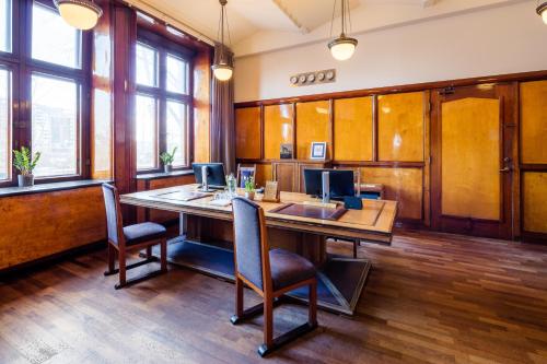 an office with a large wooden table and chairs at Grand Hotel Amrâth Amsterdam in Amsterdam