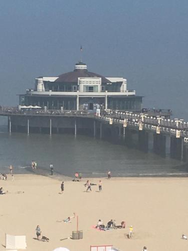 people on the beach in front of a pier at Apartment Beach in Blankenberge