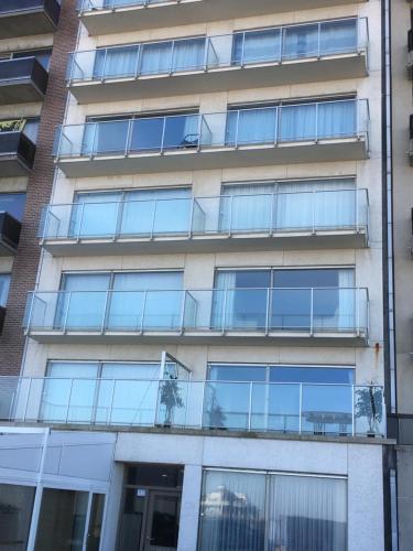 einen Außenblick auf ein Gebäude mit Glasbalkonen in der Unterkunft Apartment Beach in Blankenberge