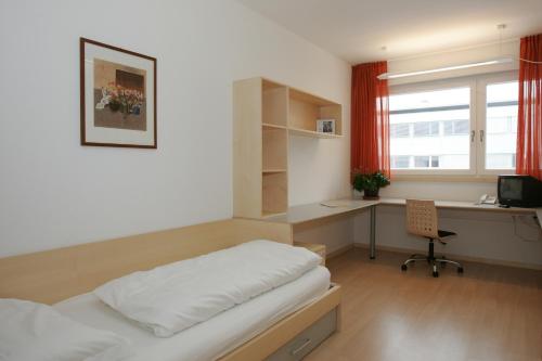Кровать или кровати в номере Kolpinghaus Bolzano