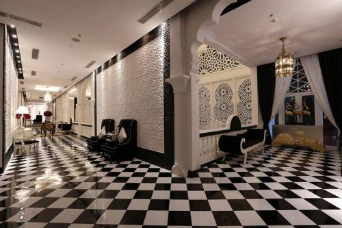 a lobby with black chairs and a checkered floor at Chloe Gallery in Ho Chi Minh City