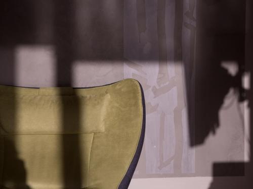 a yellow chair sitting in front of a wall at Lebensart am See in Bad Endorf