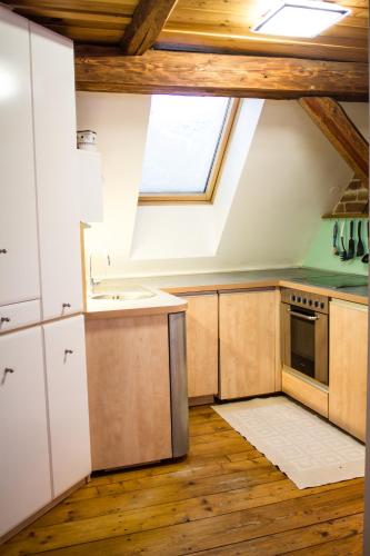 an attic kitchen with a sink and a window at Růžová chalupa u Šimánků in Rtyně v Podkrkonoší
