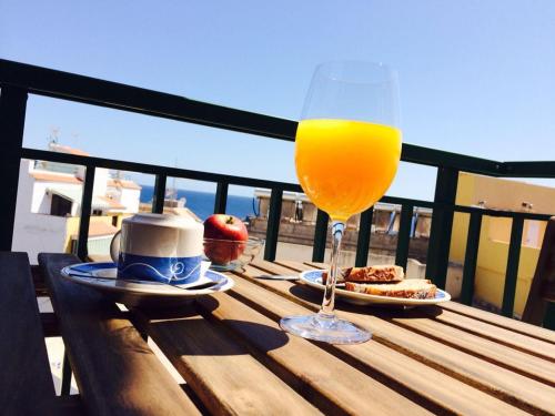 a glass of orange juice sitting on a wooden table at Hola Apartments 14-3 in Playa de San Juan