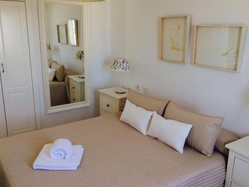 a bedroom with a bed with a towel on it at Hola Apartments 14-3 in Playa de San Juan