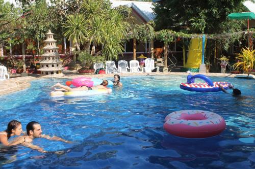 a group of children playing in a swimming pool at Deep Forest Garden Hotel in Puerto Princesa City