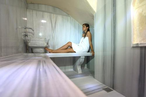 a woman in a white dress sitting in a bath tub at Hamam Oriental Suites in Rethymno Town