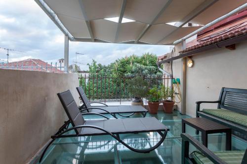 a patio with tables and chairs on a balcony at Hamam Oriental Suites in Rethymno Town