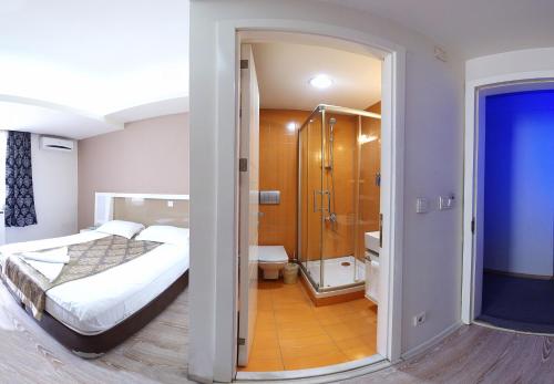 1 dormitorio con 1 cama y baño con ducha en Grand As Hotel, en Estambul