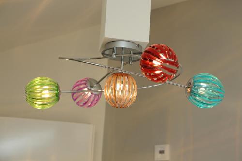 a chandelier with four colorful lights hanging from a ceiling at Lebensart am See in Bad Endorf