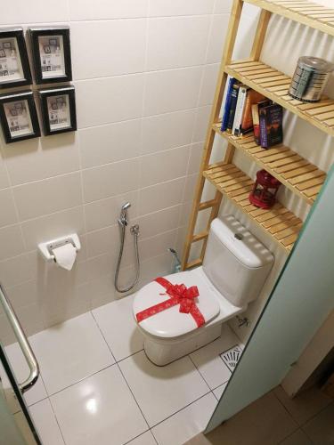 a bathroom with a toilet with a red bow on it at De Houz @ Setia Alam Trefoil Homestay in Shah Alam