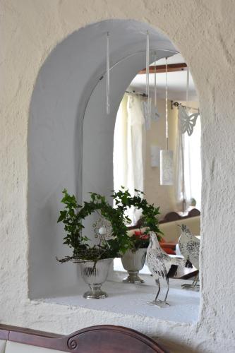 a mirror with two vases with plants in a room at Landhotel Gillenfelder Hof in Gillenfeld