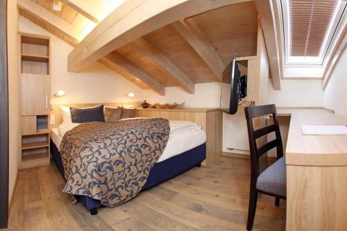 a bedroom with a bed and a desk with a chair at Lebensart am See in Bad Endorf
