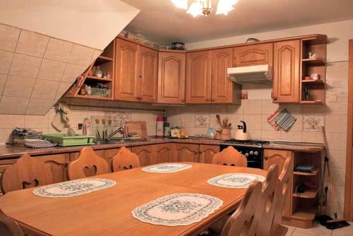 a kitchen with a wooden table and wooden cabinets at Willa Gorska Koleba in Zakopane