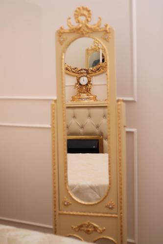 a gold dresser with a mirror and a clock at DONNA LUCREZIA b&b Boutique Hotel Style - relax & business stay in Bisceglie