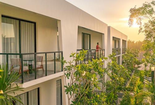 un uomo in piedi sul balcone di un edificio di Metta Residence & Spa a Siem Reap