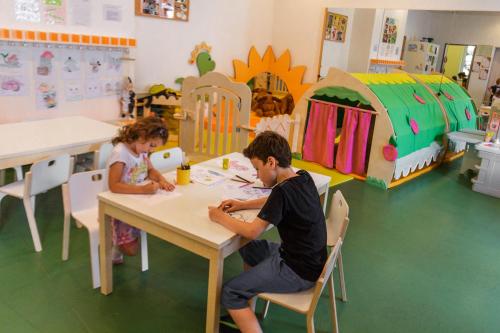 a boy and a girl sitting at a table in a classroom at Sporthotel Wagrain in Wagrain