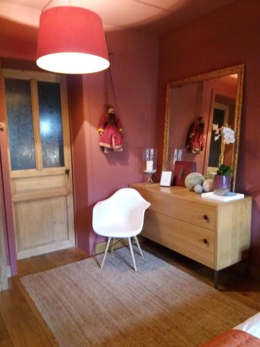 a room with a mirror and a chair and a dresser at B&B La Chambre d'à Côté in Aische-en-Refail