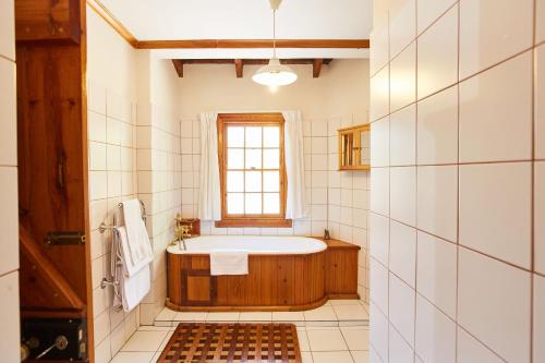 a bathroom with a tub and a window at Paquita Self Catering Holiday House in Knysna