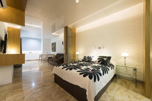 a bedroom with a bed and a brick wall at Suites Garden Loft Andy Warhol in Las Palmas de Gran Canaria