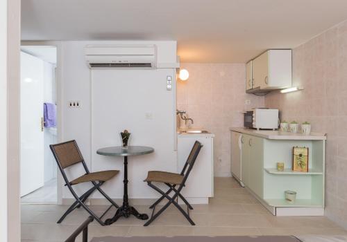 a small kitchen with a table and chairs in a room at Studio Amore in Dubrovnik