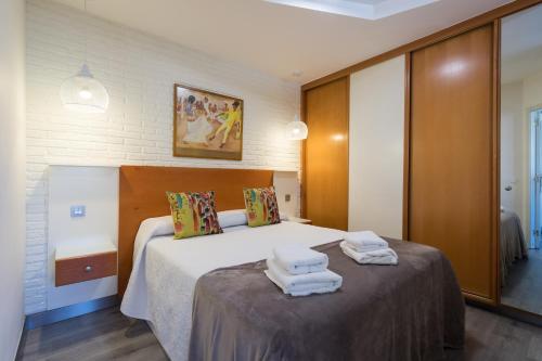 1 dormitorio con 1 cama con toallas en Suites Garden Apartamento 42, en Las Palmas de Gran Canaria