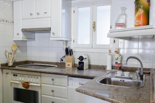 a kitchen with white cabinets and a sink at Casa Maitetxu in Puente la Reina