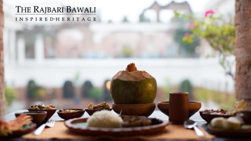 a table with plates of food on a table at The Rajbari Bawali in Kolkata