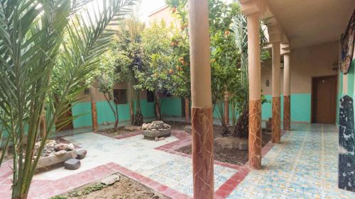 a courtyard with trees and plants in a building at Kasbah Hotel Camping Jurassique in Ifri