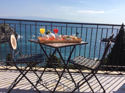 a table with a tray of food and drinks on a balcony at Jonic Hotel Mazzarò in Taormina