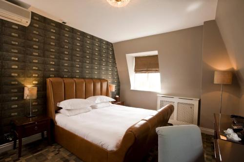a bedroom with a large bed and a window at Hotel du Vin Cannizaro House Wimbledon in London