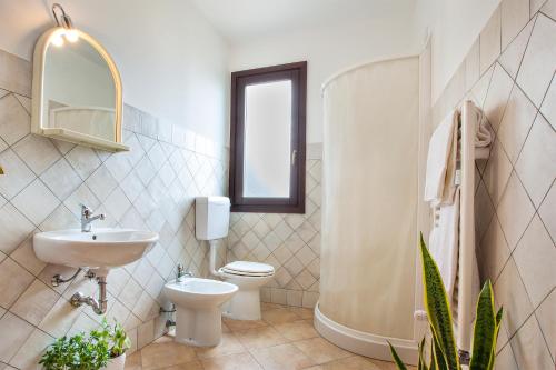 a bathroom with a sink and a toilet and a window at Hotel Terra degli Elimi in Buseto Palizzolo