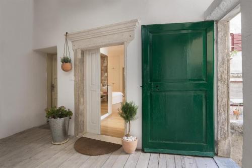 an open green door in a room with potted plants at That place studio apartment in Trogir