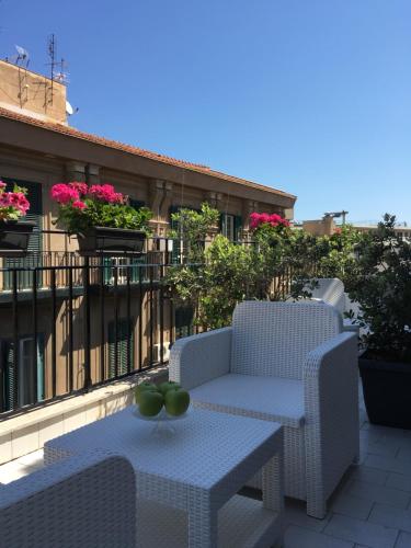 Un patio con dos sillas y una mesa en un balcón. en Dimora Villareale, en Palermo