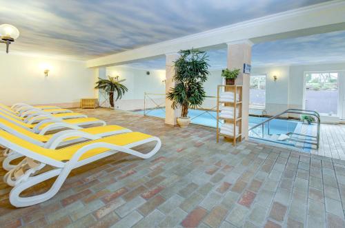 a room with four beds and a swimming pool at PTI Hotel Eichwald in Bad Wörishofen