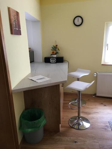 a room with a counter and a stool and a clock at Gästehaus Windheim (Karlsruher Denkmal) in Karlsruhe